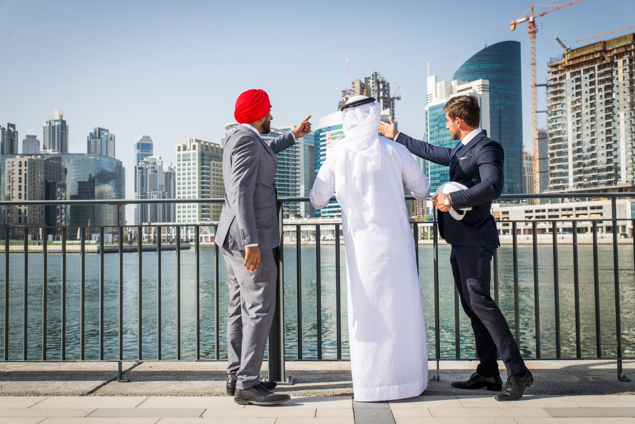 Two businessmen discussing construction plans overlooking a city skyline